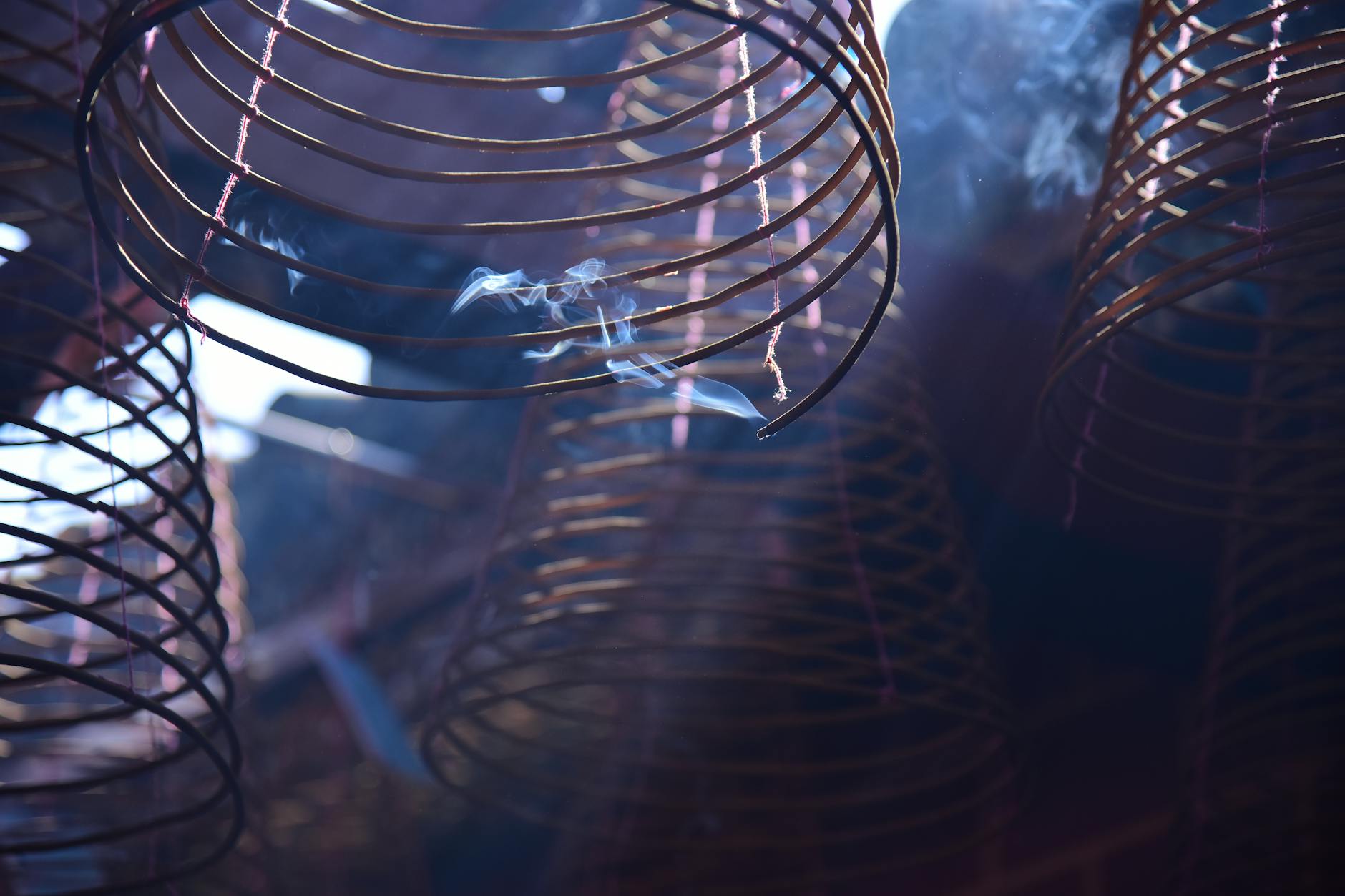 Incense sticks burning in a traditional shrine with smoke rising delicately