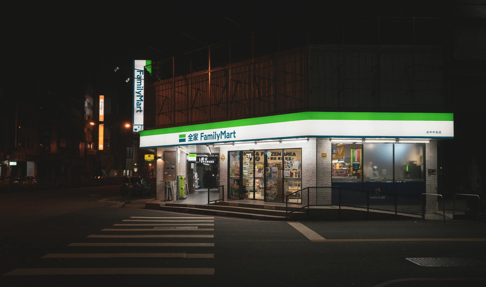 Illuminated FamilyMart store facade on city street at night