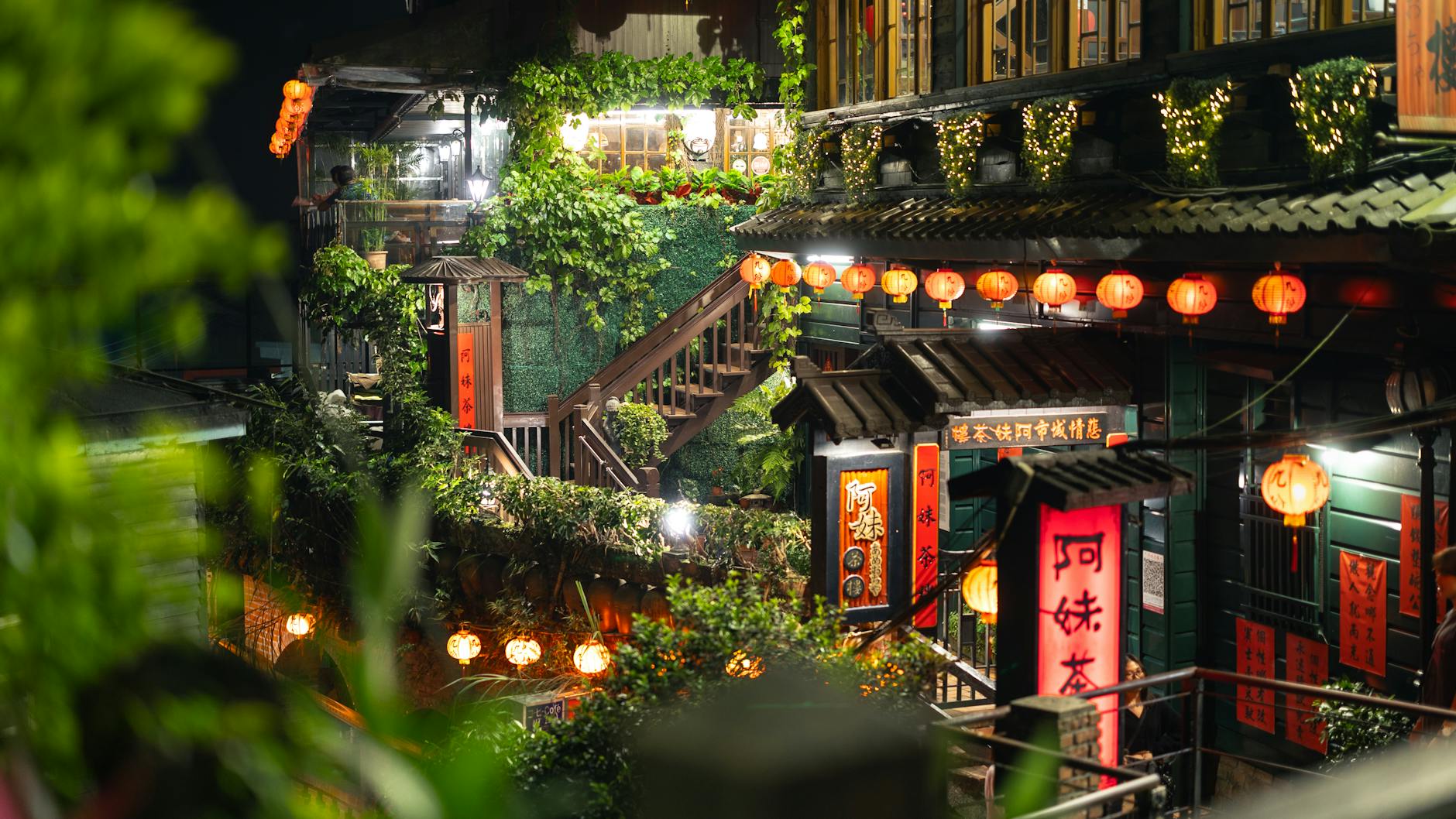 Red lanterns illuminating a narrow stone-paved street in Jiufen at dusk