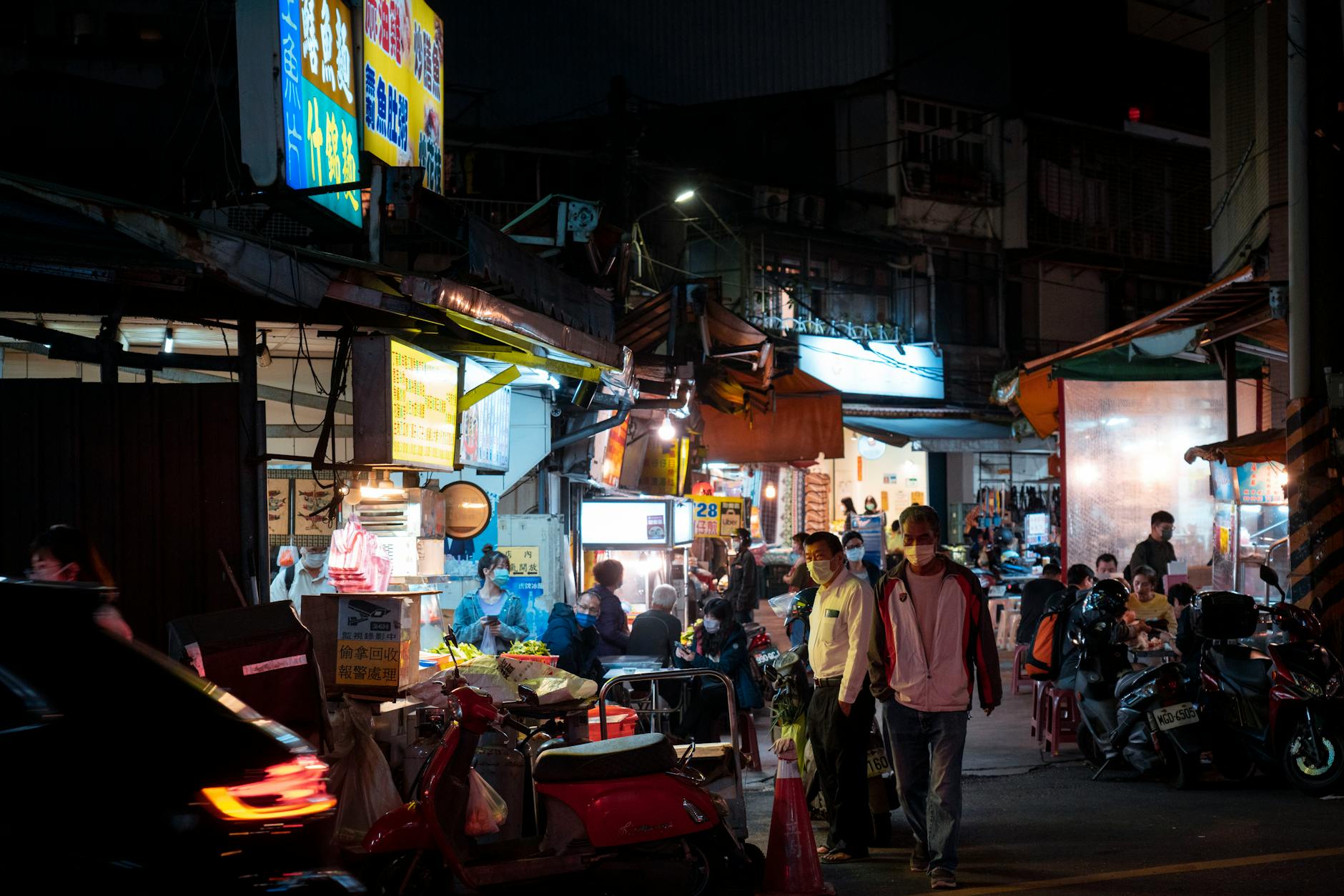 Lively Taipei night market scene with food stalls and people in a bustling urban setting