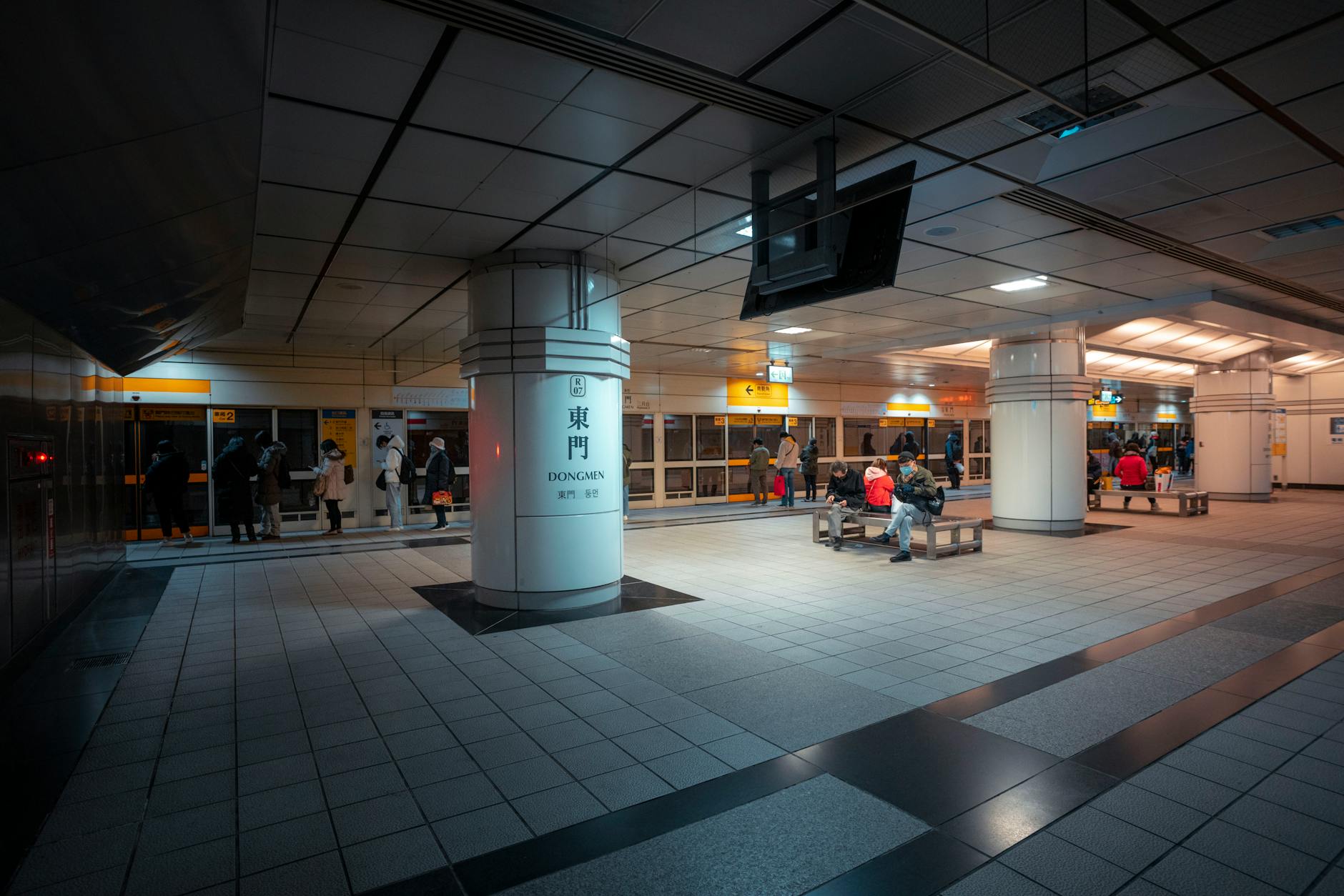 Passengers waiting at a Taipei Metro station platform with modern architecture