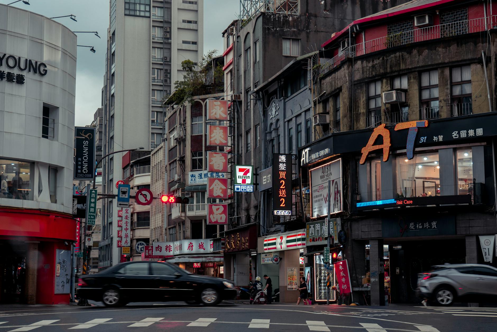 Vibrant urban street in Taipei with busy traffic and neon-lit storefronts