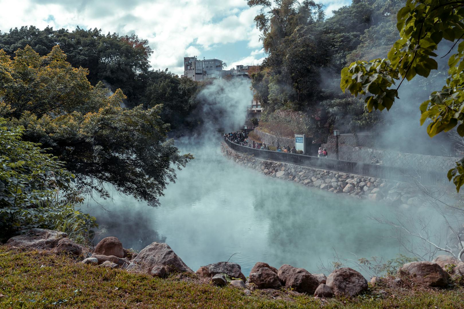 Outdoor public hot spring pool in Beitou surrounded by lush greenery