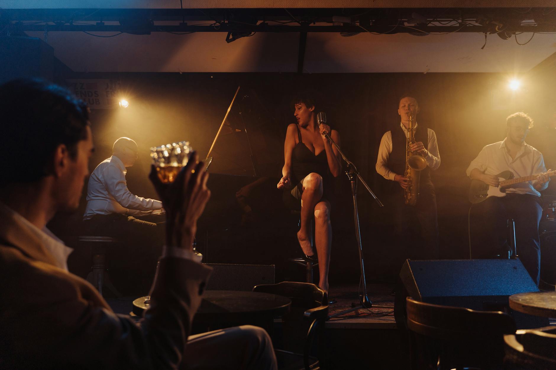 Jazz band performing live on stage with a singer in a cozy bar