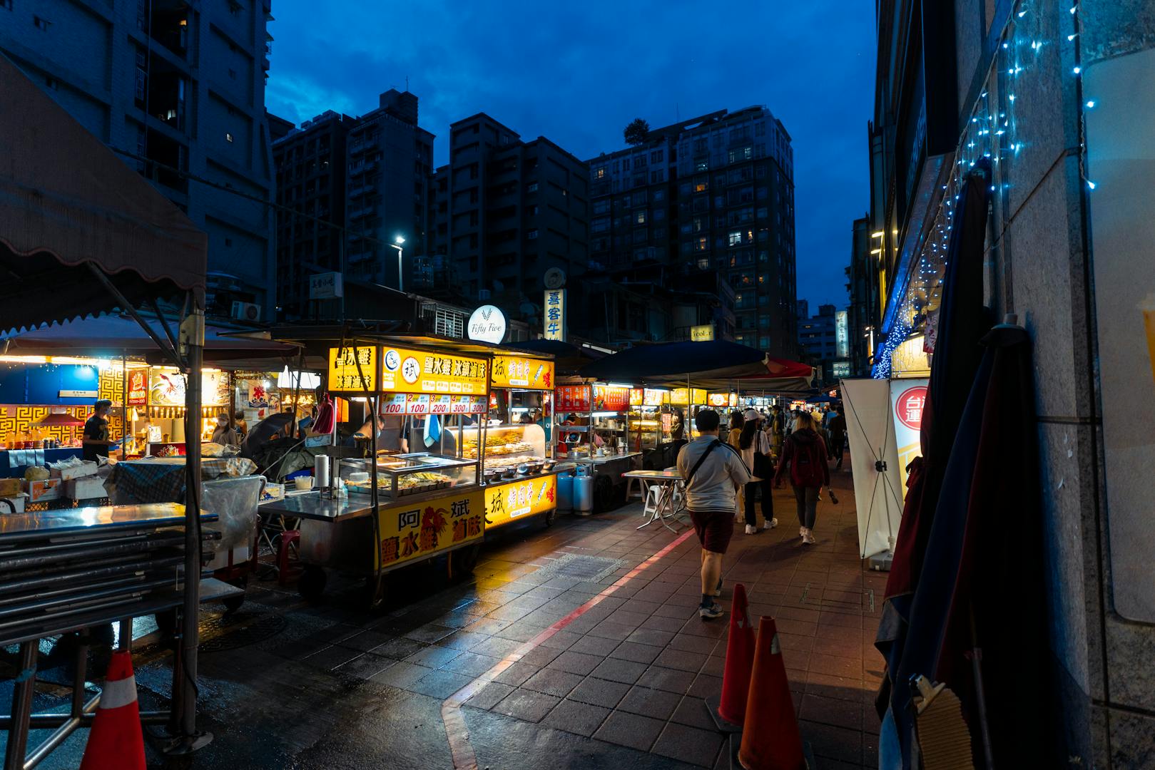 Miaokou Night Market food stalls with crowds in Keelung Taiwan