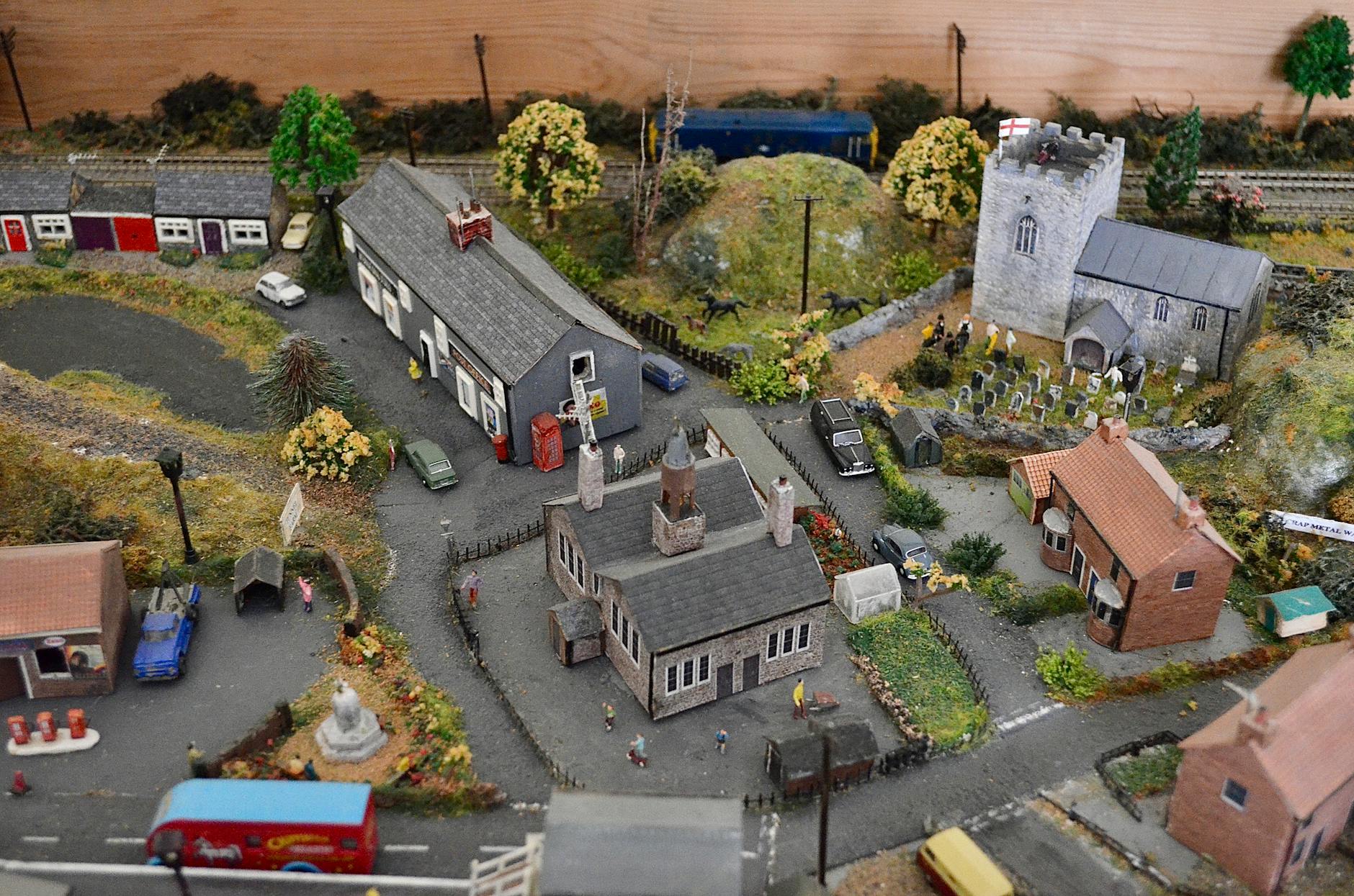 Detailed model diorama showcasing a miniature village with buildings and vehicles
