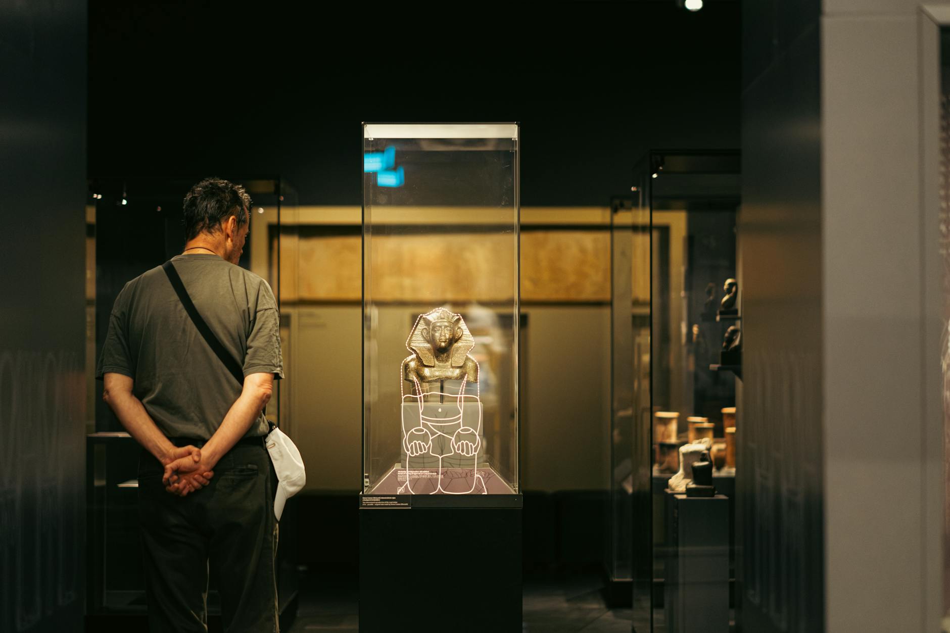 Visitor observing ancient artifact display in a museum exhibit