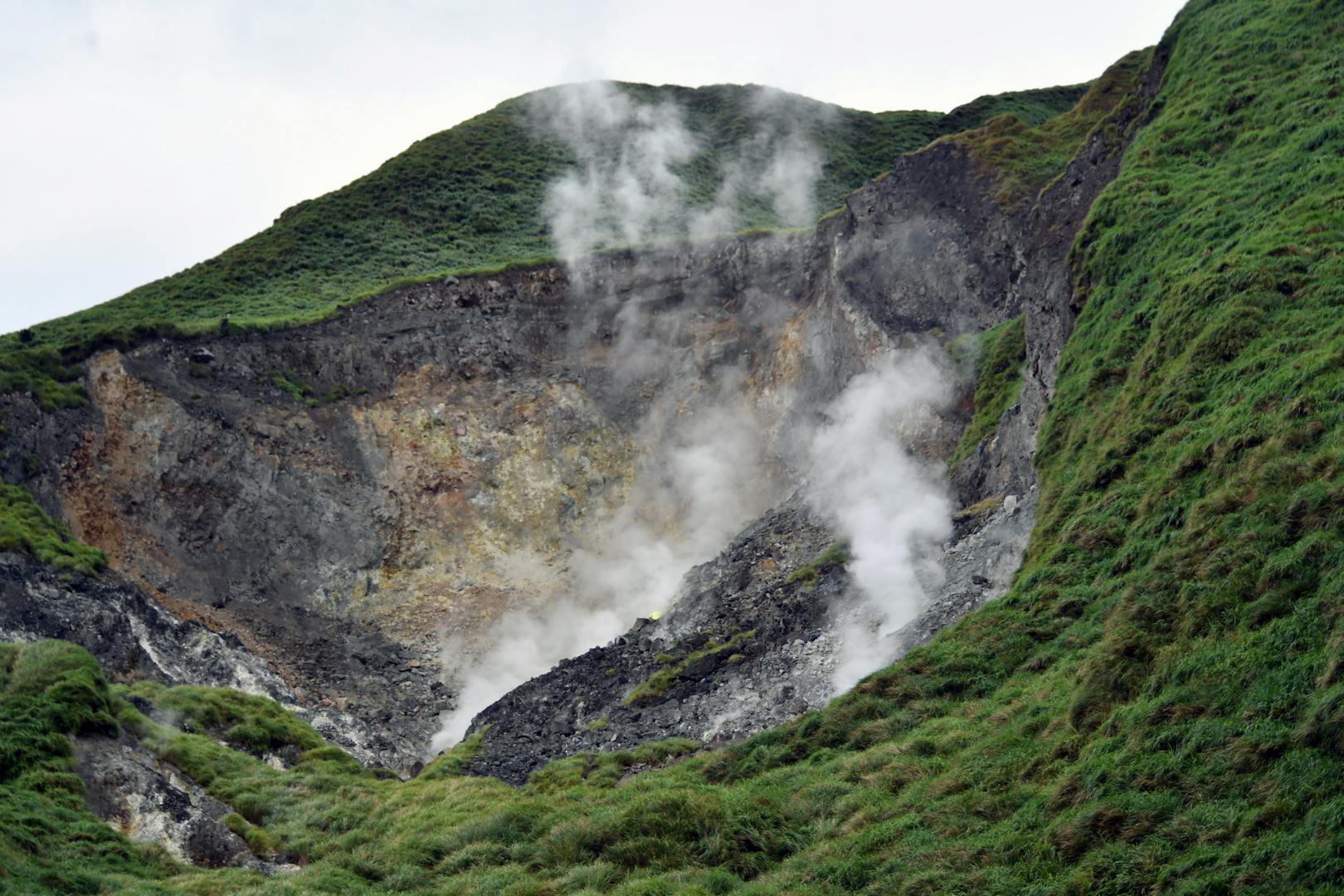 Hikers on the Qixingshan trail at Yangmingshan with grasslands and mountain views