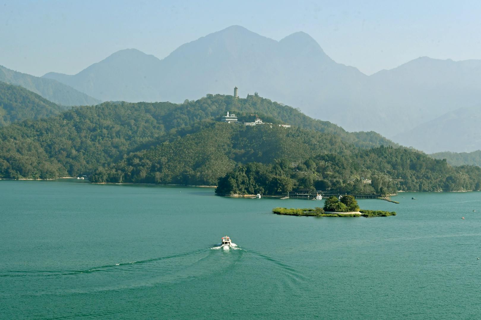Tourist boat on Sun Moon Lake with mountain backdrop