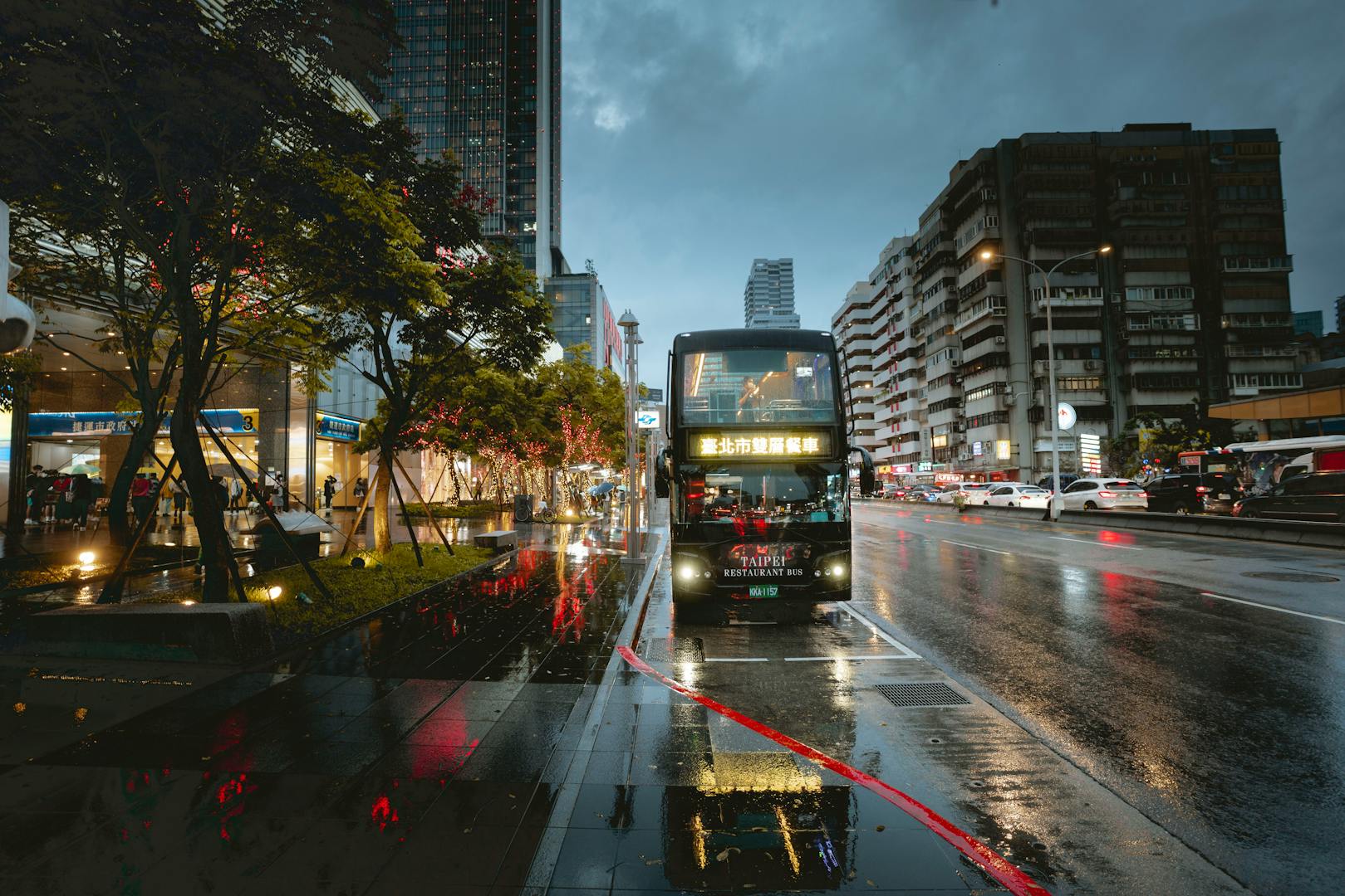Taipei city bus on a busy street with passengers boarding