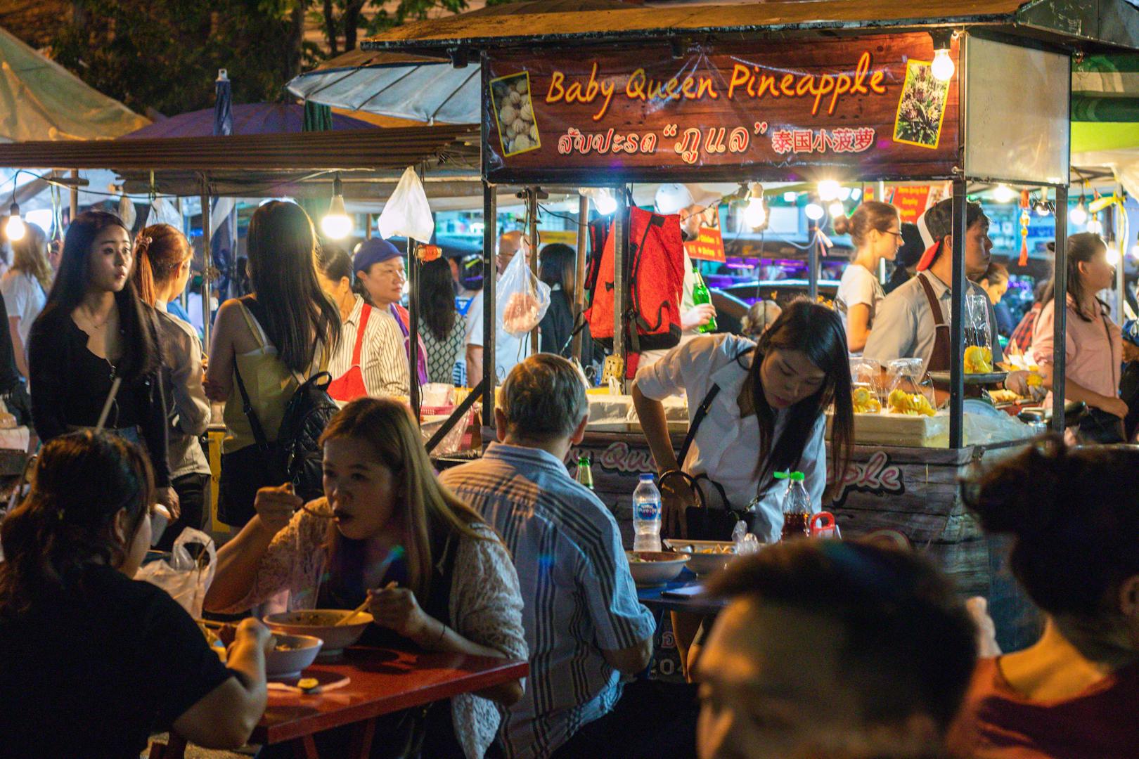 Crowds eating night market food at a Taipei night market in the evening