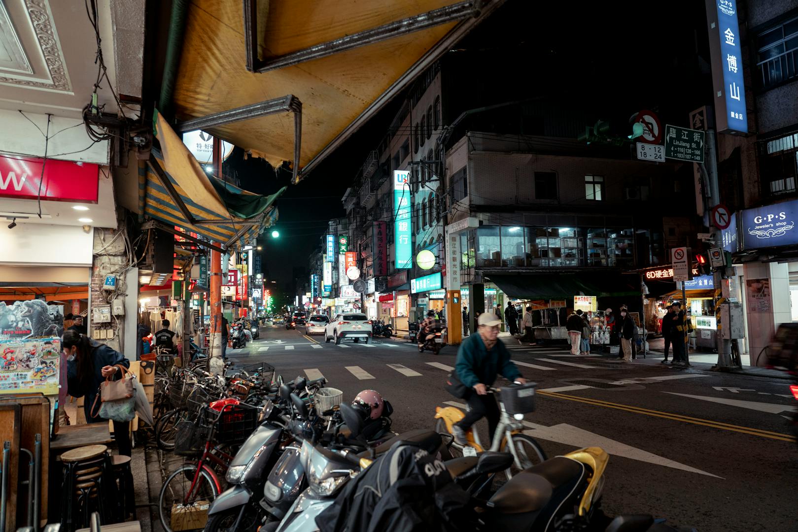 Quiet Taipei street at night with pedestrians safely walking