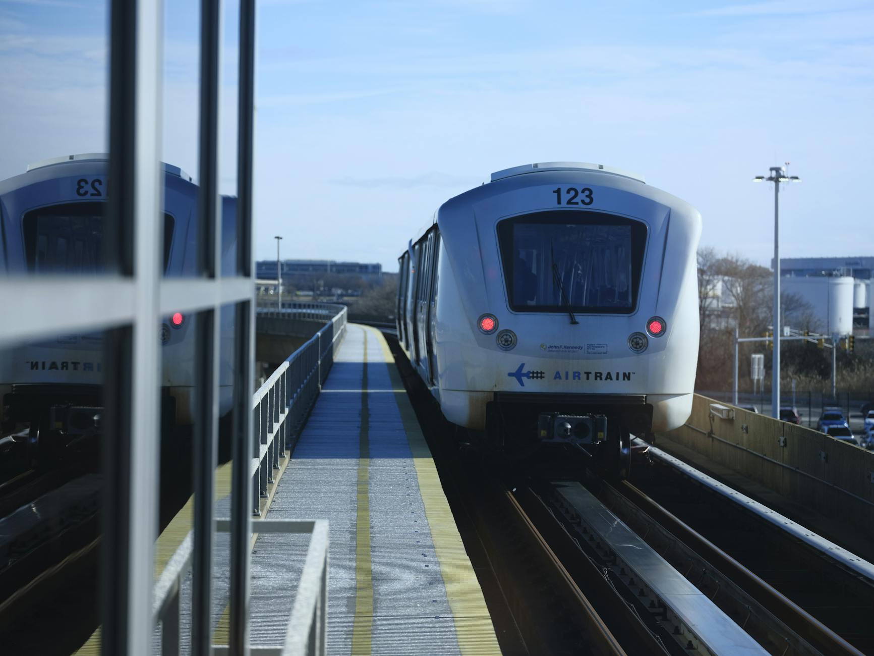 AirTrain approaches an airport station on a clear day