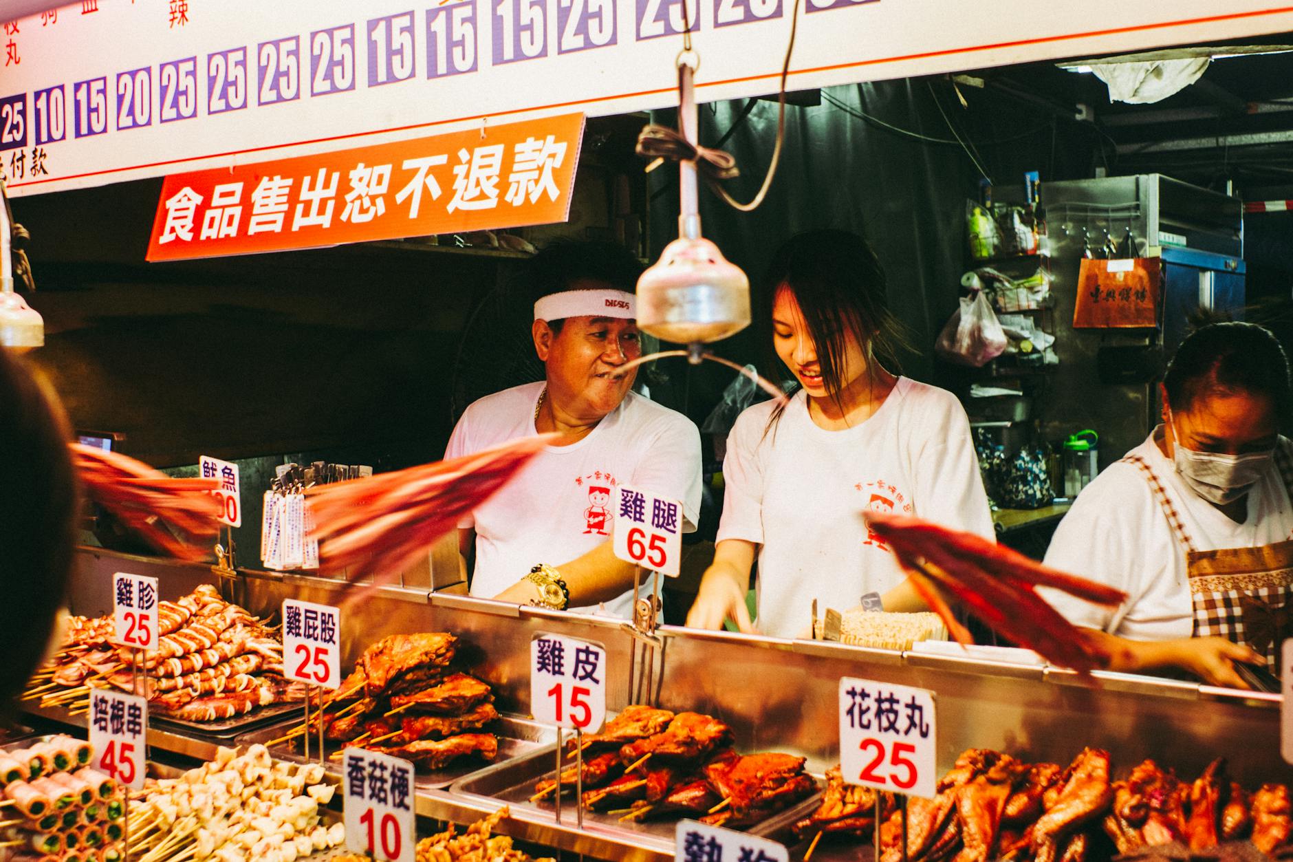 Bustling Taiwanese night market food stall with vendors