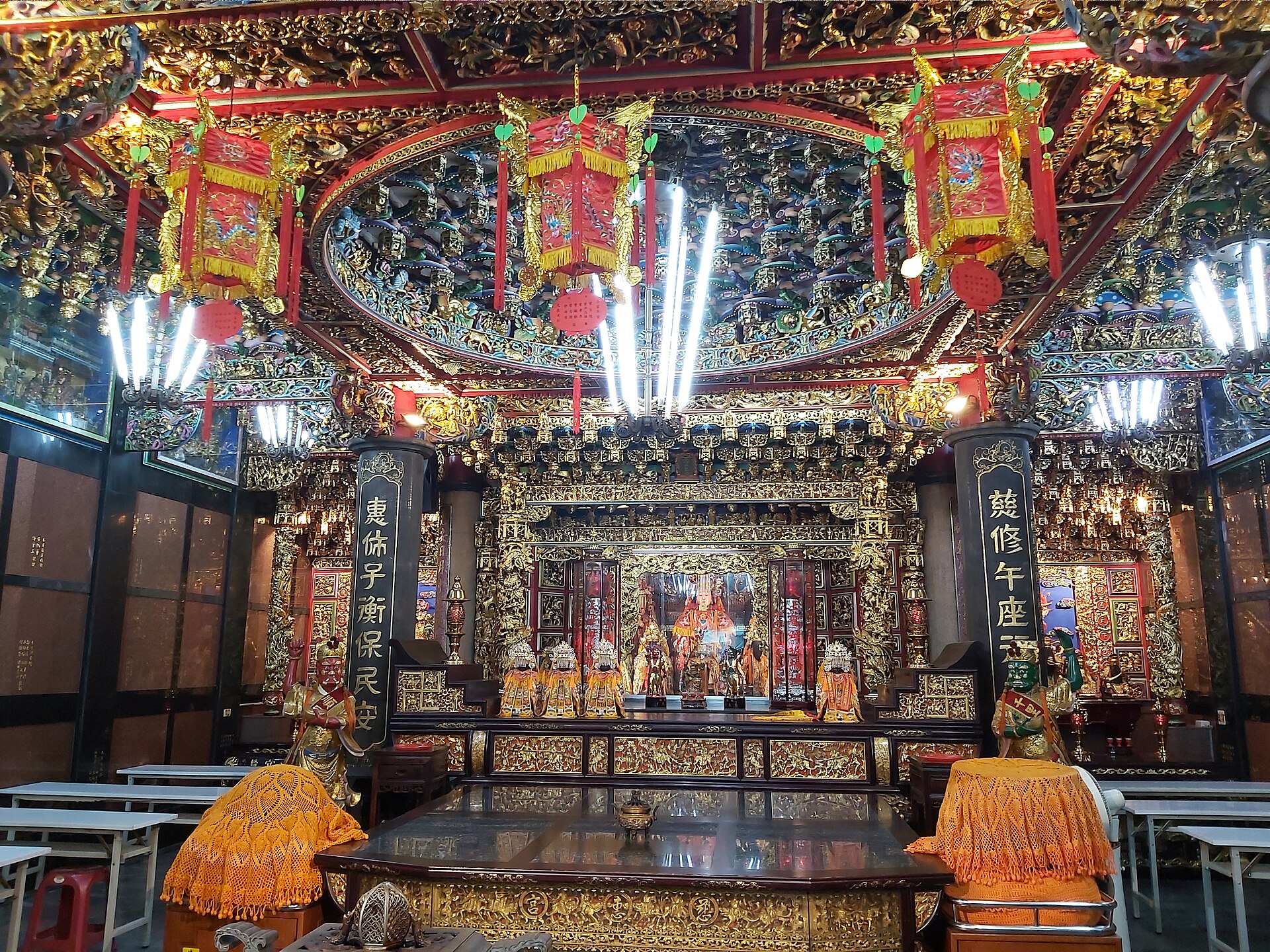 The gilded main altar of Cihui Temple in Banqiao, with statues of Mazu and attendant deities under red lanterns and an elaborately carved caisson ceiling