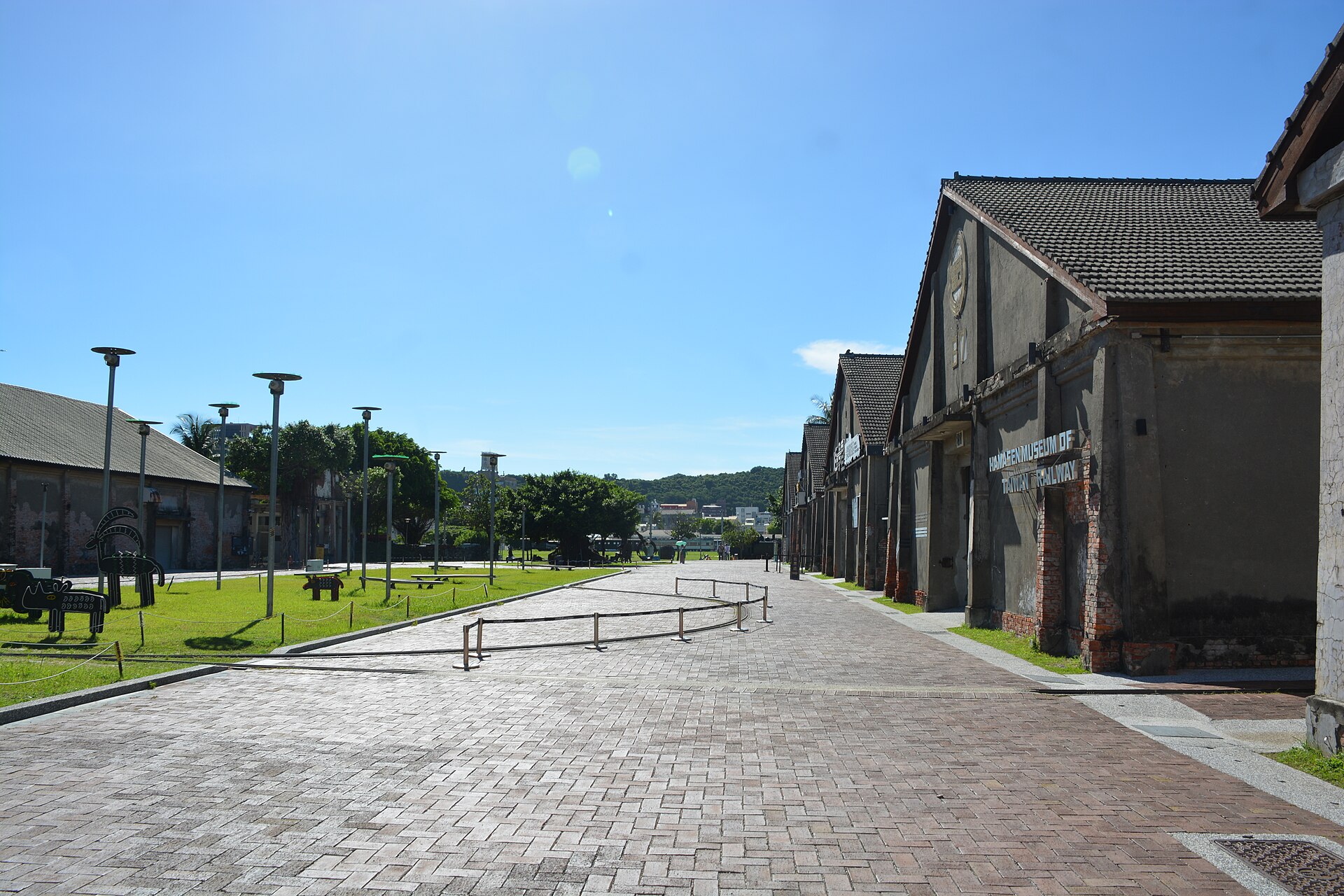 Restored brick and tile warehouses along a wide paved street at the Pier-2 Art Center in Kaohsiung