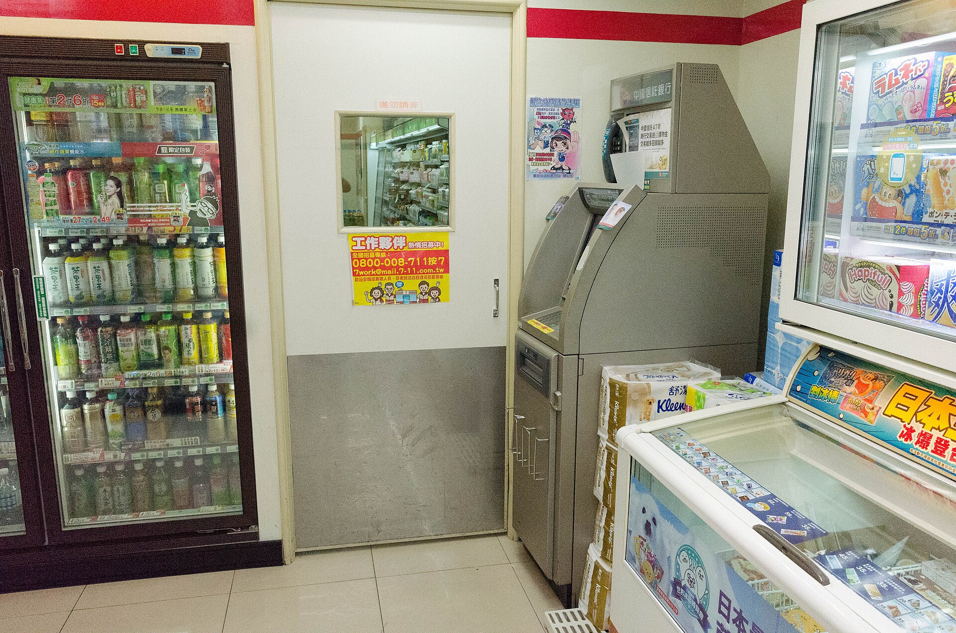 An ATM inside a Taiwanese 7-Eleven next to drinks fridges