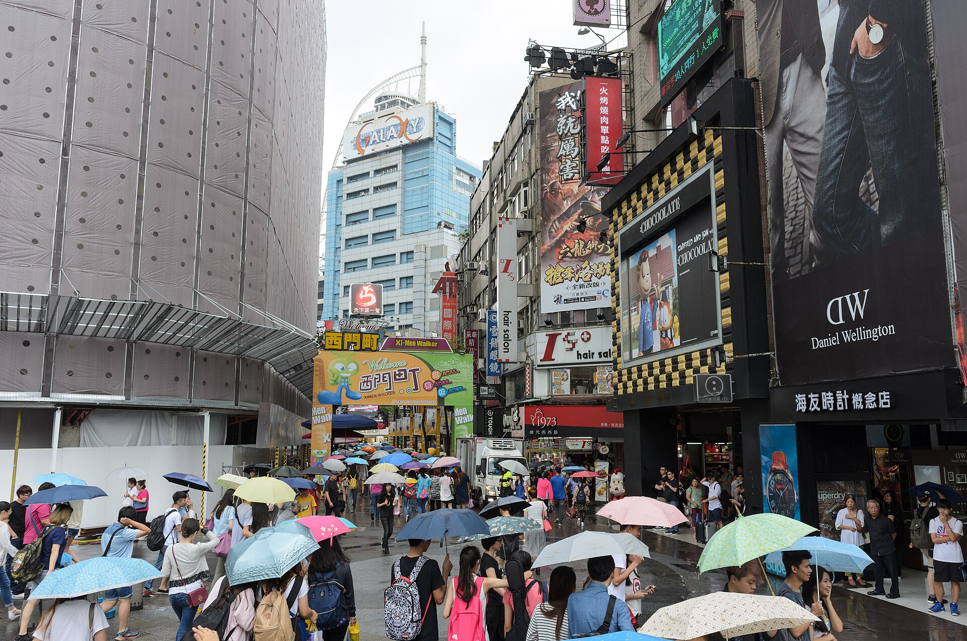 Crowds of pedestrians carrying umbrellas on a wet street in Ximending, Taipei