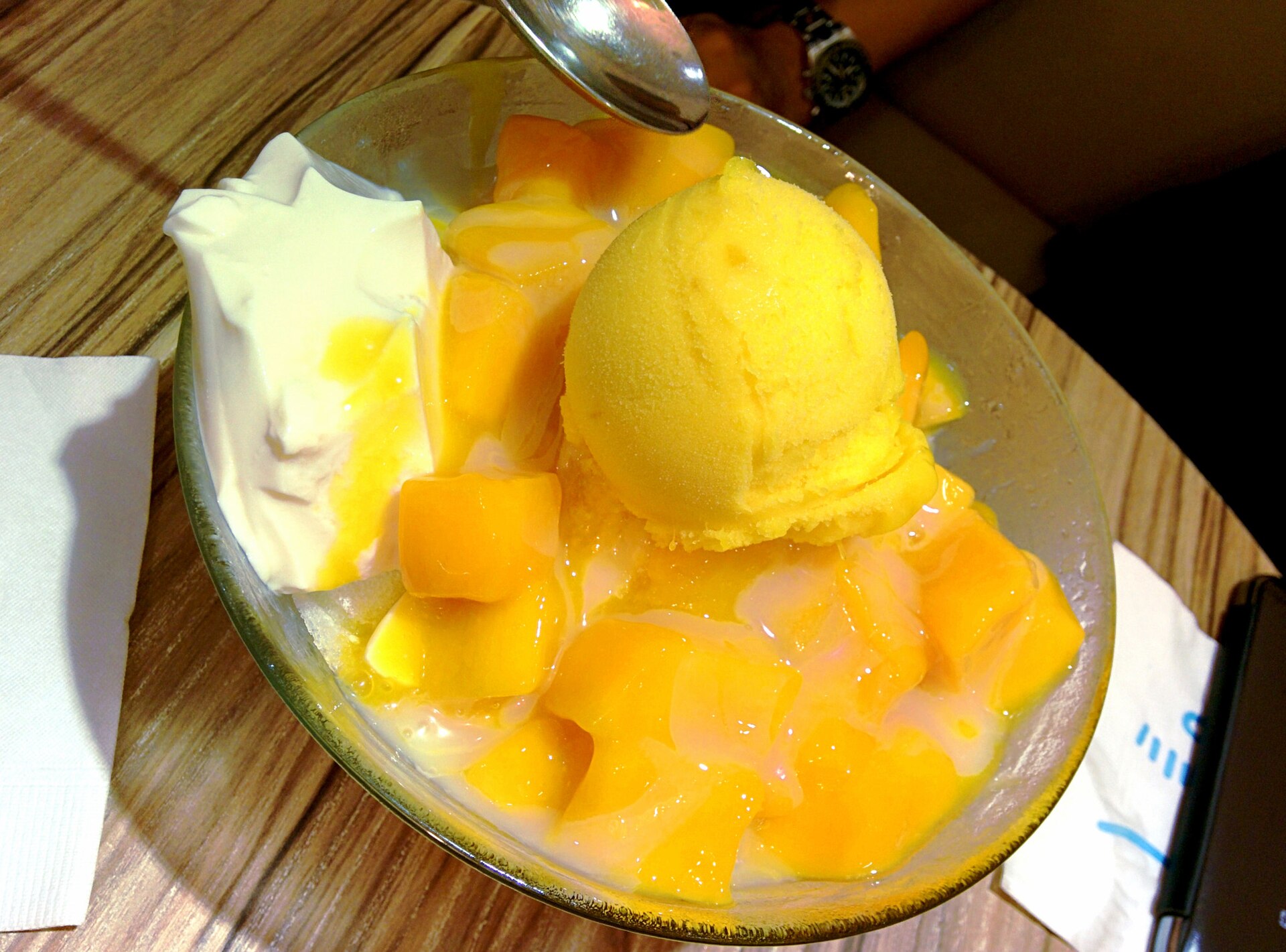 Mango pieces, a yellow frozen scoop and white topping fill a shaved-ice bowl at Taipei Ice Monster.