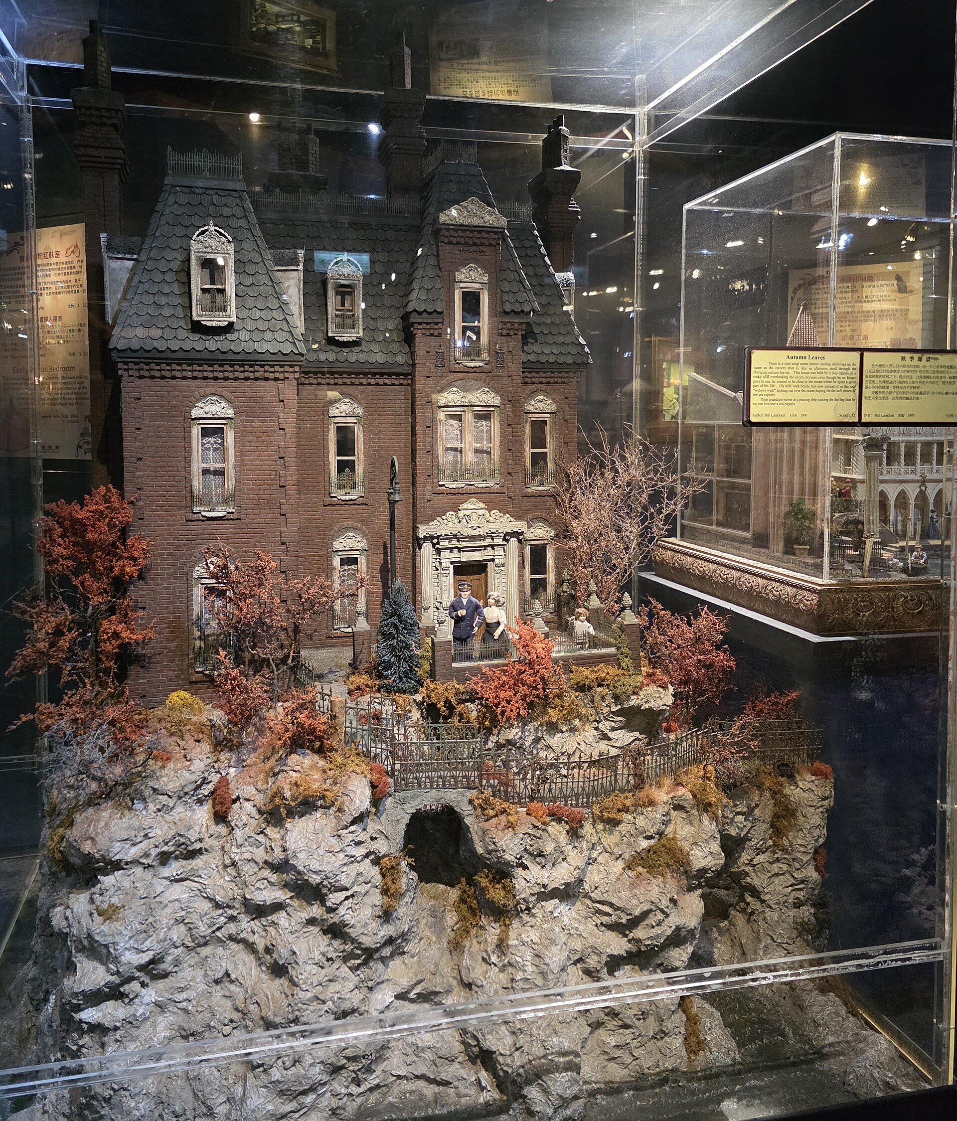 A miniature brick mansion rises above autumn trees and a rocky garden at the Miniatures Museum of Taiwan in Taipei.