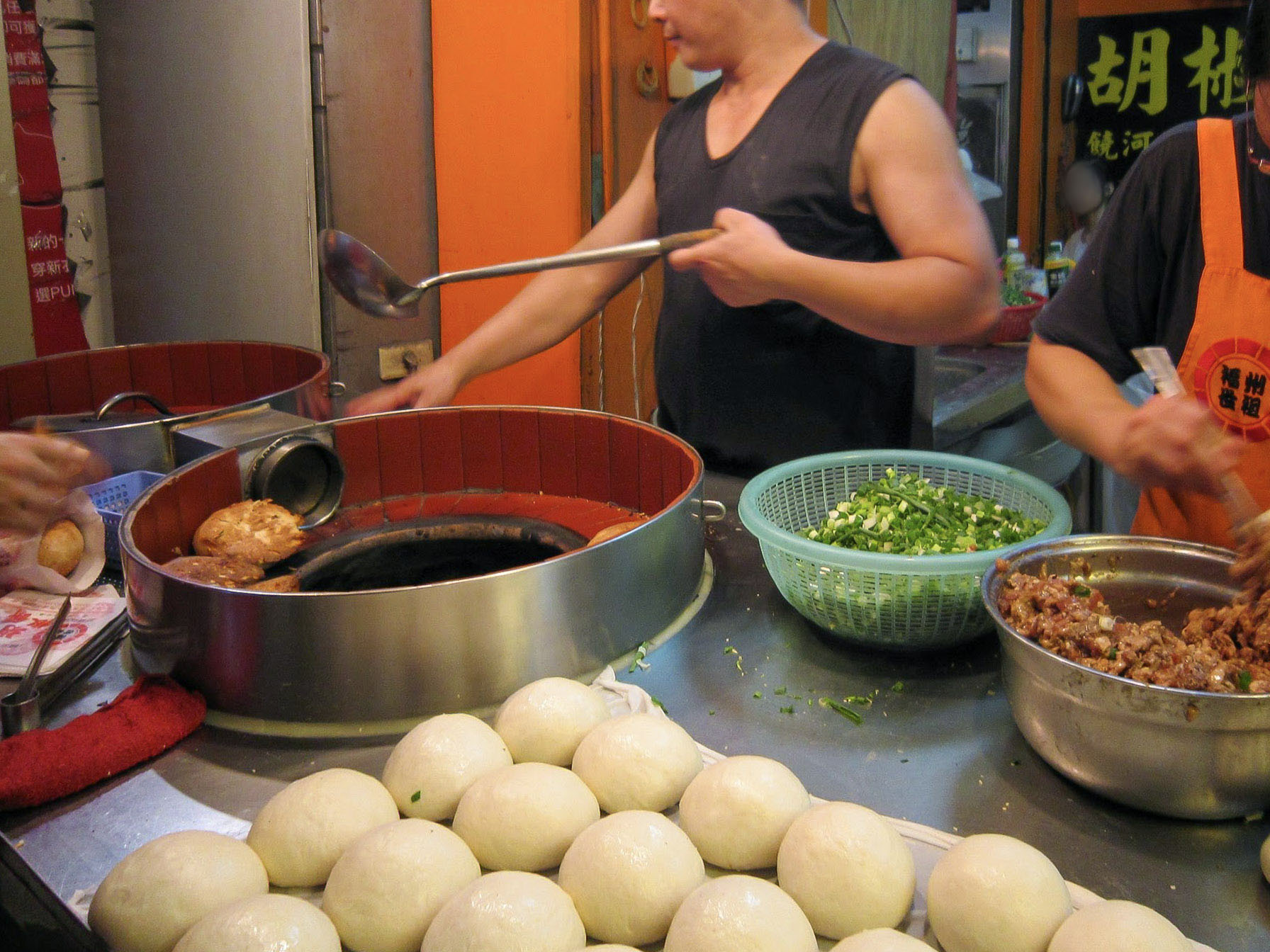 Pepper bun dough and filling surround a cylindrical oven at Fuzhou Shizu in Taipei.
