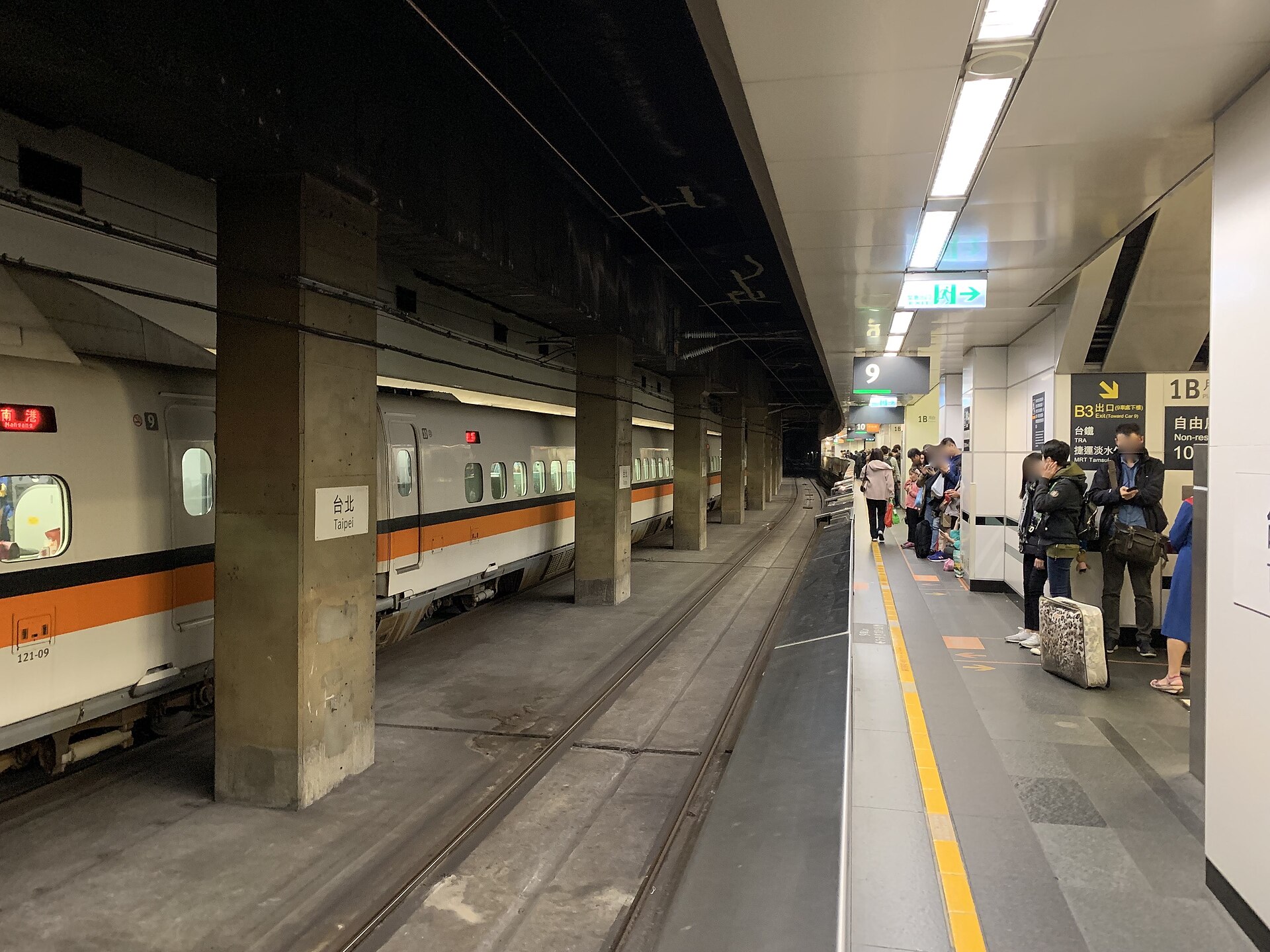 A Taiwan High Speed Rail train stands beside waiting passengers on the underground platform at Taipei Main Station.
