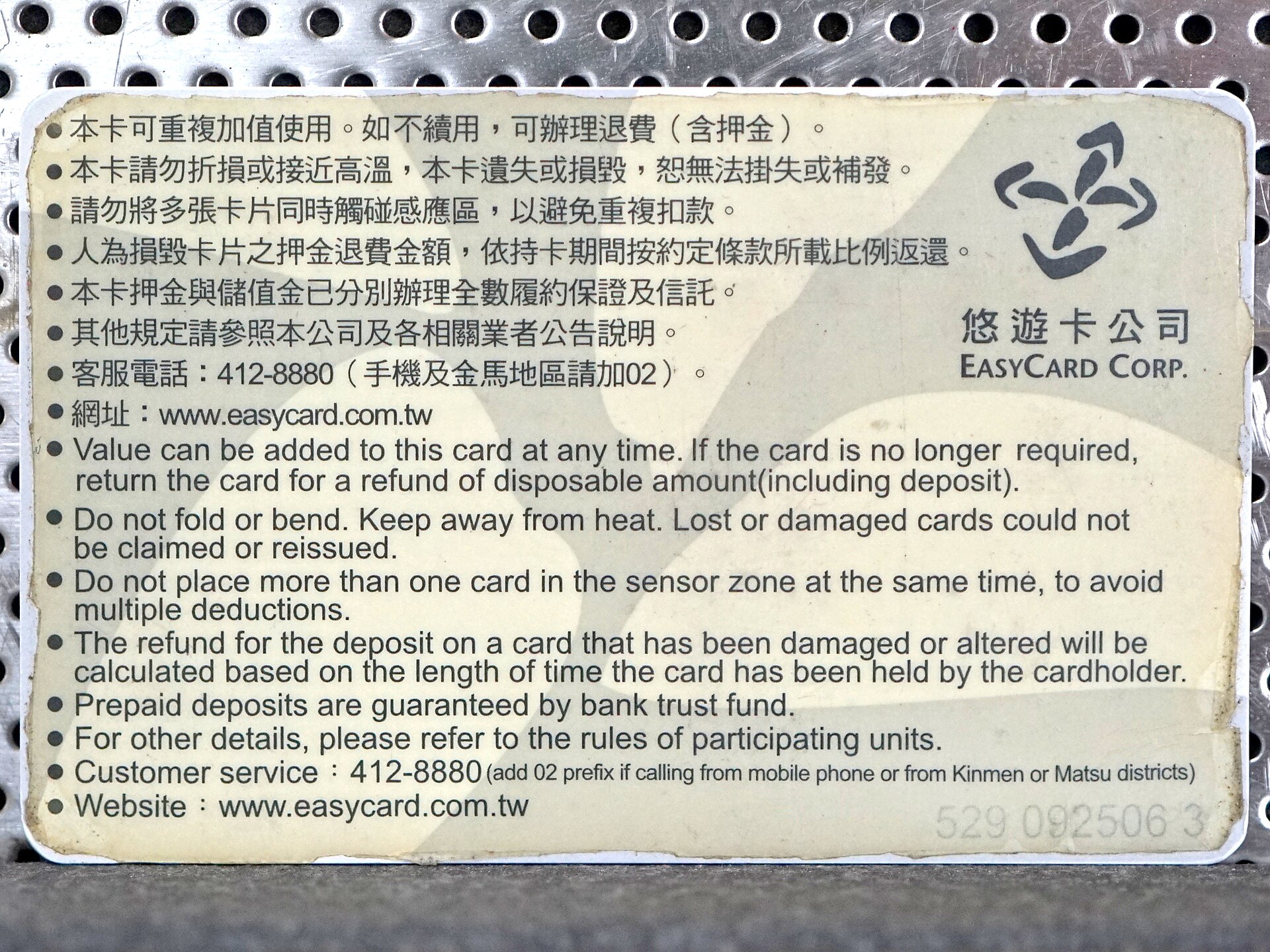 A worn adult EasyCard displays bilingual instructions and the EasyCard company logo on its reverse side.